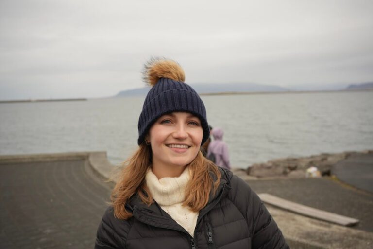 A female solo traveler stands in front of the Sun Voyager sculpture, one of the interesting things to do in Reykjavik Iceland.