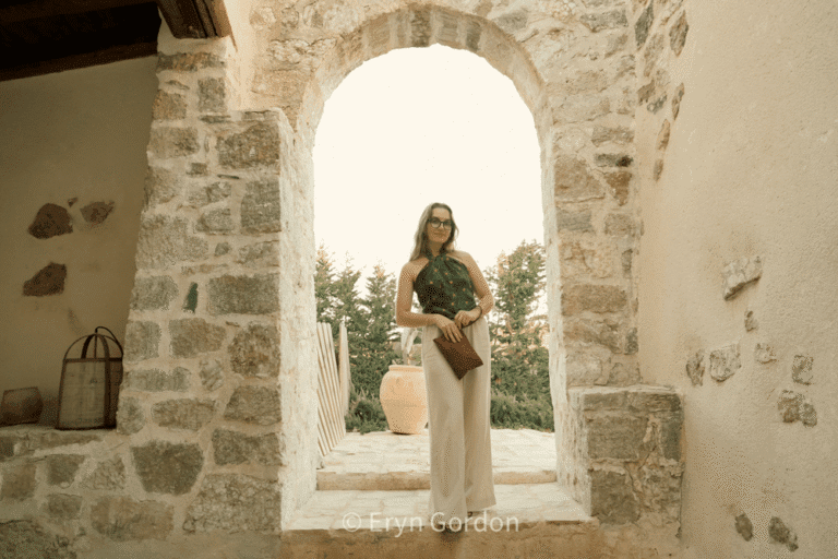 The editor of Earth To Editorial posing next to an open door in Borgo delle Pietro, an agritourism in Sicily.